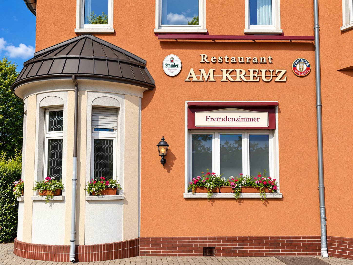 Fassade des Restaurants Am Kreuz mit Erker und Blumen