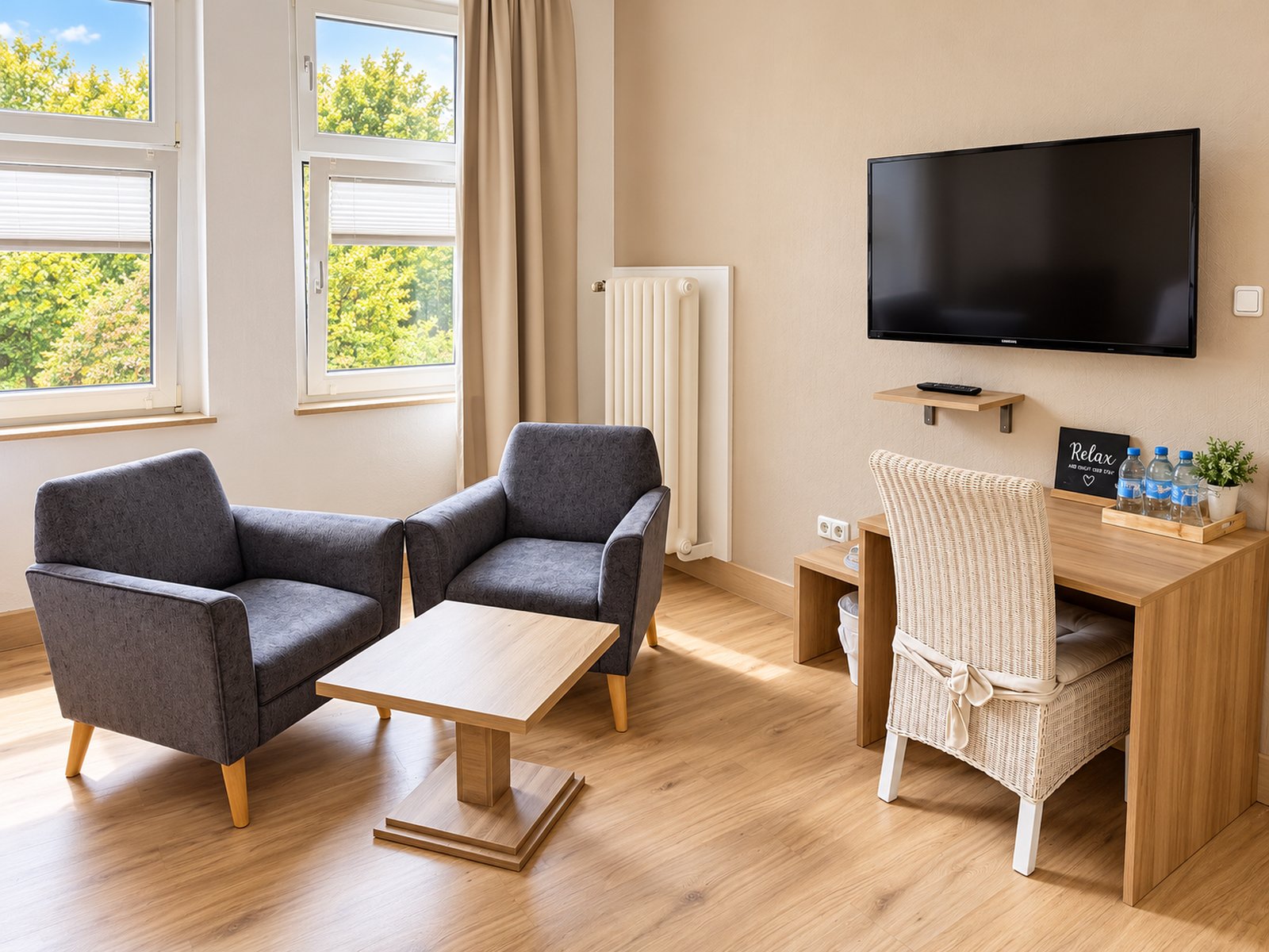 Wohnecke mit Sesseln, Fernseher und Schreibtisch
